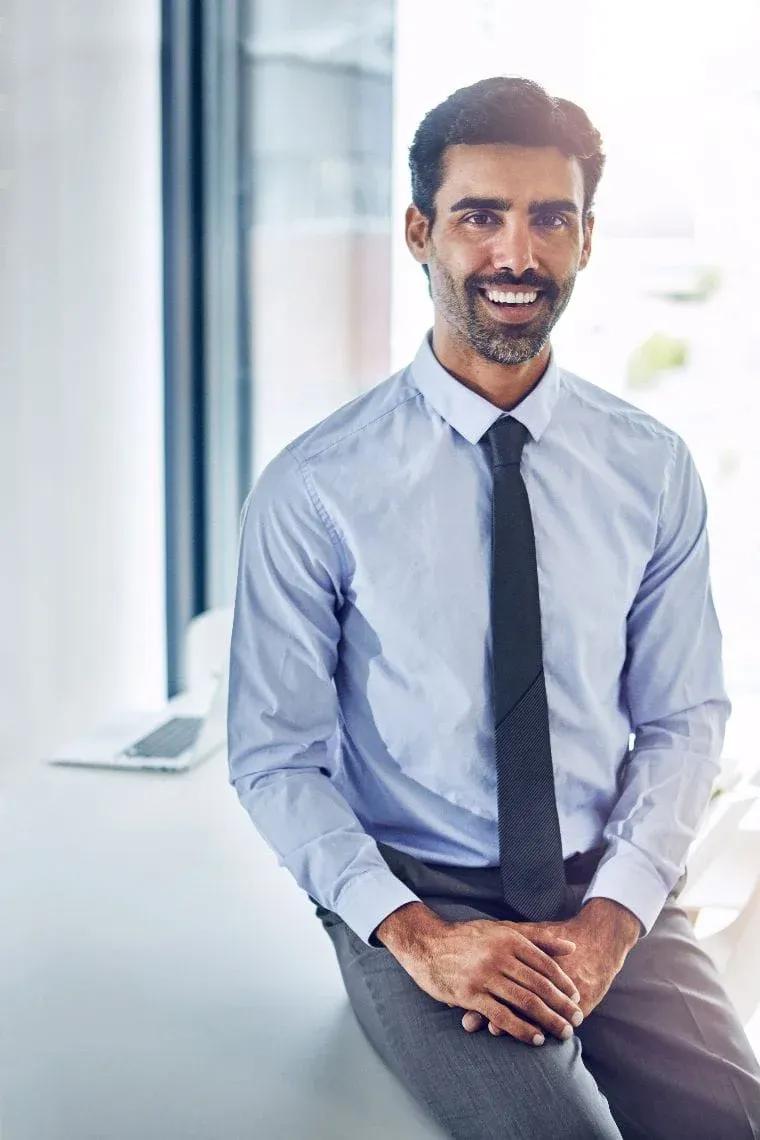 Asesor de Global Bróker en Madrid, sentado en un escritorio de oficina, transmitiendo confianza y cercanía profesional.